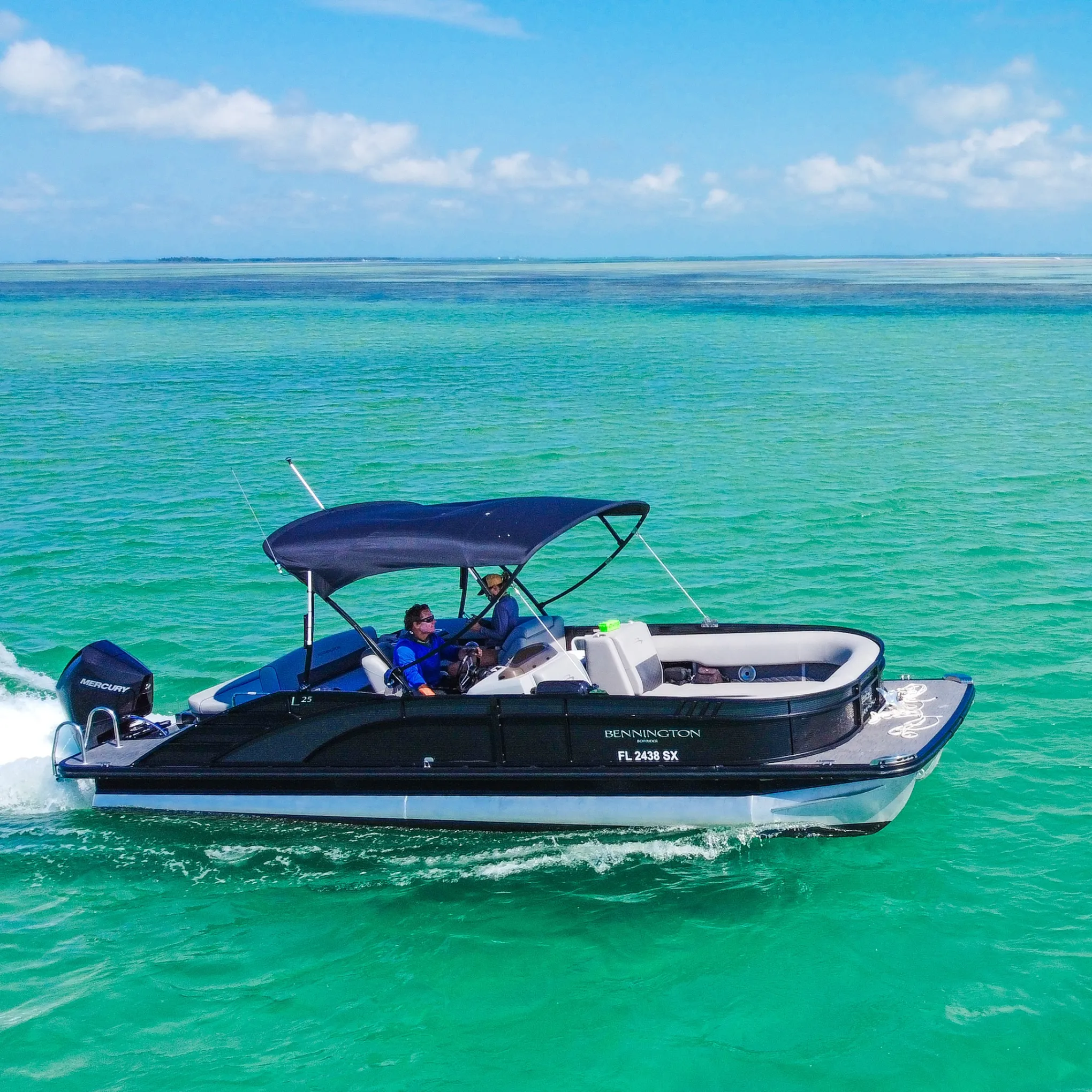 Small motorboat with canopy cruising on clear turquoise water under blue sky.